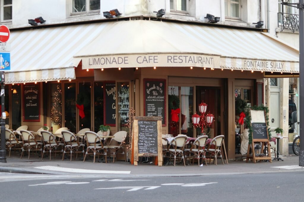 A charming corner cafe restaurant with a striped awning.